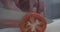 Closeup of man hands cutting tomato in the restaurant kitchen