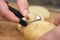 Closeup of man hands peeling a potato with a swiss vegetable peeler