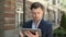 Closeup man holding modern touchpad at street. Man browsing internet on tablet