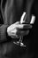 Closeup of a man holding a wine glass in front of his body. Person is unrecognizable