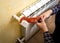 Closeup of man installing radiator valve with red plumber pliers