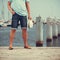 Closeup of man legs on pier in port with yachts.