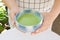 Closeup of man person hands holding Japanese traditional matcha green tea in a cup