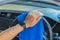 Closeup for man polishing cleaning car steering wheel with microfiber cloth