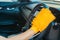 Closeup for man polishing cleaning car steering wheel with microfiber cloth