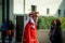 Closeup man in red costume walks by city street full of people dominican carnival