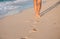 Closeup of a man`s bare feet walking at a beach at sunset,