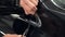 Closeup of a man`s hands folding edges of vinyl film to cover chrome elements of expensive car.