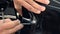 Closeup of a man`s hands folding edges of vinyl film to cover chrome elements of expensive car.