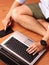 Closeup of a man sitting typing on keybord of his laptop and his smartphone simultaneously.