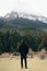 Closeup of a man standing and admiring a natural view of mountains in Lake Doxa, Greece