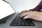 Closeup of a man typing on a laptop keyboard