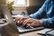 Closeup man typing on laptop keyboard, shallow depth