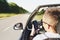 Closeup of man using a smartphone while driving a car. driving into oncoming traffic. Dangerous movement. Distracted by phone. The