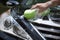 Closeup man washing new black car hood with big soft sponge, soap suds