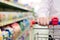 Closeup on man or woman hand in shop with shopping trolley or cart on the supermarket shelf background