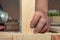 Closeup man works with handheld battery screwdriver on wooden surface