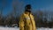 Closeup man in yellow jacket sliding snowboarder look around in winter city park.