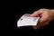 Closeup of a mans hand holding a pack of euros banknotes