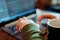 Closeup mans hands freelancer sitting in cafe working laptop