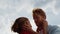 Closeup married lovers hug outdoors. Joyful couple touch cheek on summer sky