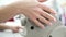 Closeup of married woman hand rotating wheel of sewing machine during operation