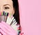 Closeup. master in pink medicine gloves keeps with nail varnish samples display on background with text space