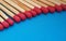 Closeup of matchsticks in a row over blue background.