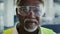 Closeup Of Mature Black Construction Worker In Protective Helmet, Vest And Eyeglasses