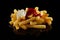 Closeup of mayonnaise and ketchup on pile of appetizing crinkle cut French fries on a black table