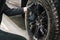 Closeup of a mechanic performing a detailed tire cleaning on a car's rim, using specialized tools