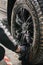 Closeup of a mechanic performing a detailed tire cleaning on a car's rim, using specialized tools