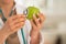 Closeup on medical doctor woman examining apple