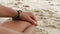 Closeup of meditation hands, man sitting in lotus on the beach