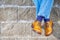 Closeup of Mens Legs Wearing Brown Oxfords Semi Brogues Shoes. Posing Outdoors Against Stony Grunge Background