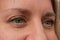 Closeup of middle aged woman face with green eyes. Real skin without make up and correction. Do not look at camera. Smiled