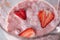 Closeup of a milky-berry shake blender with slices of ripe strawberries. Healthy dessert. Top view