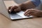 Closeup of millennial male hands typing on modern laptop keyboard