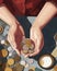 A closeup of a millennials hands holding coins and bills representing the successful balance between managing debt and