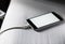 Closeup of mobile phone charging and lying on white fabric background