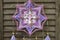 Closeup modern dreamcatcher star mandala with amethyst and peacock feathers on wooden background