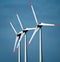 Closeup of modern windmills against a blue sky