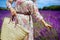 Closeup on modern woman with straw bag touching lavender