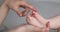 Closeup mom hand caress chubby bare toes of newborn infant