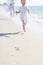 Closeup on mother and baby running along sea shore