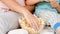 Closeup of mother and son in pajamas taking popcorn from big glass bowl while watching cartoons or movie in bed. Concept