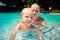 closeup mother teaches small daughter swim smile in azure pool