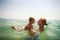Closeup mother teaches swim small daughter in azure sea