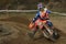 Closeup of a motorcyclist riding a dirt bike along a rugged course