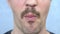 Closeup mouth. handsome mustachioed man happily eats a stalk of celery